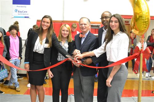 students at a ribbon cutting with the mayor and assistant principal 