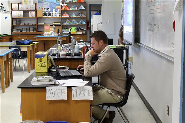 Intern Josh Cummings sits at a desk on Jan. 29, working on his computer in biology teacher Phillip Muszynski’s classroom. 