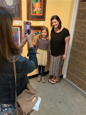 Student and adult posing with artwork 