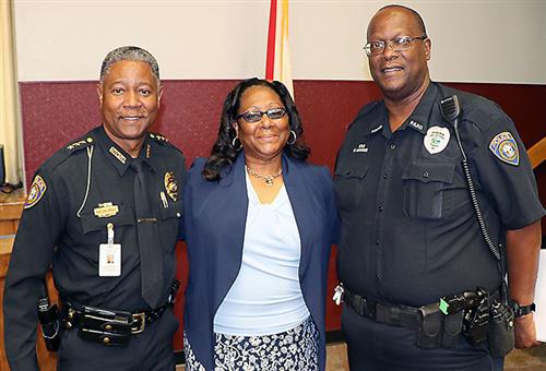 Pictured left to right: Schools Police Chief Luke Williams, Stacey Hawkins (wife) and Officer Michael Hawkins. 