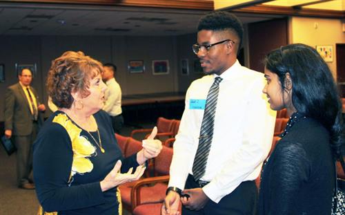 Students speak with a board member after SR&R meeting 