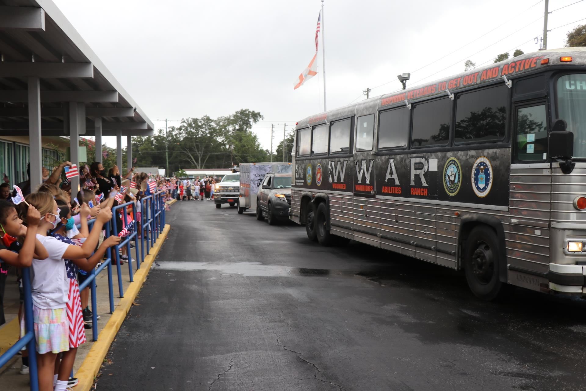 Bus with students waving flags