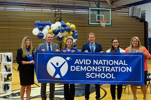 School leaders hold a banner that reads AVID National Demonstration School