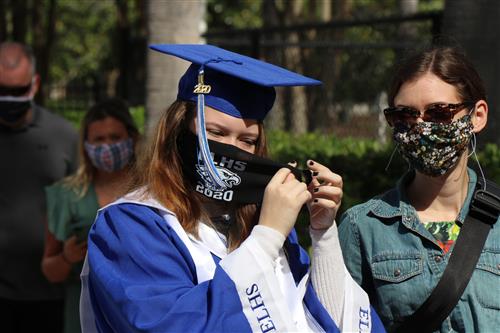 East Lake High Student puts on mask. 