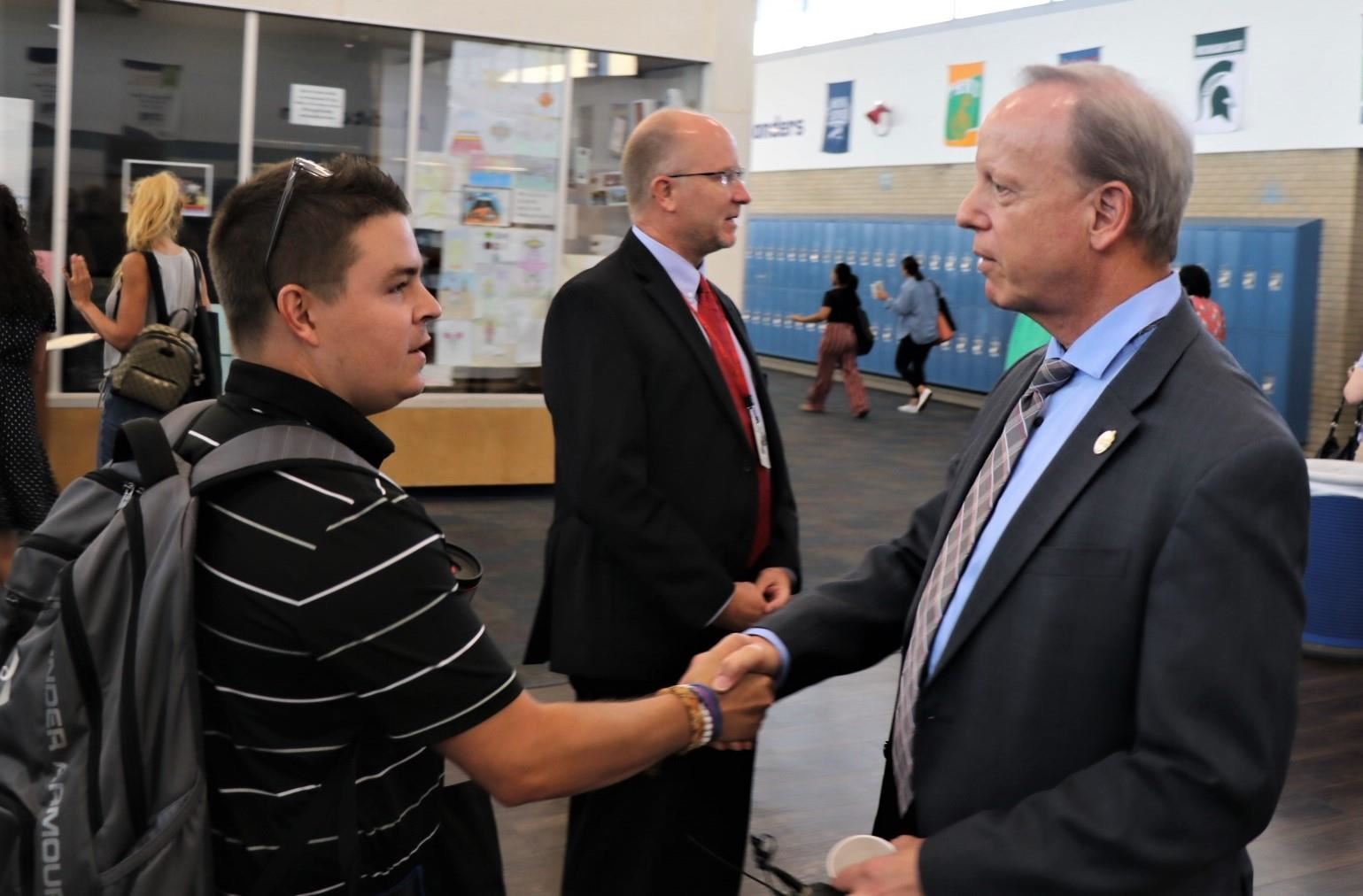 Dr. Grego shakes new teacher's  hand