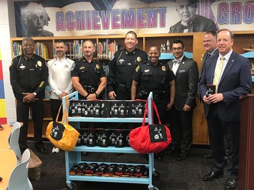 Police officers, Dr. Grego and Dr. Ovalle show Tiny Totes bags.