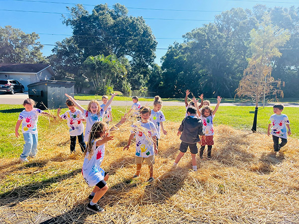 San Jose Elementary Kindergarten students play in hay.