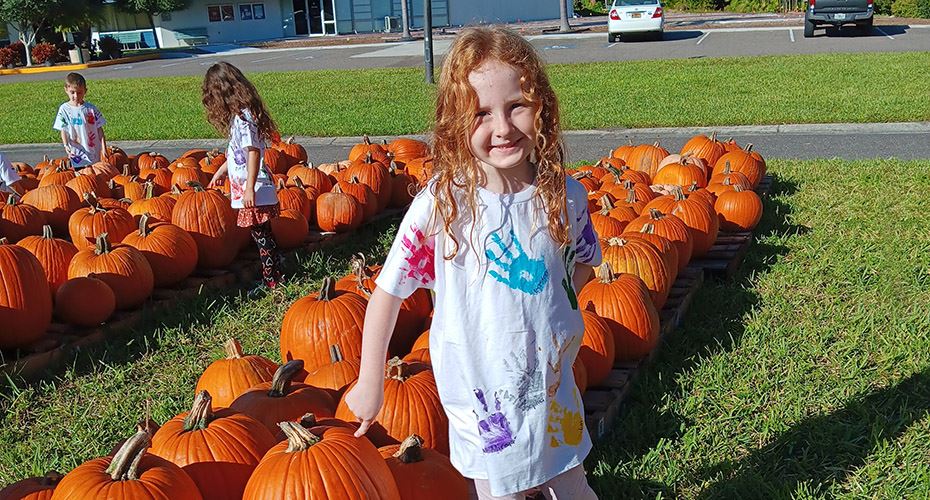 San Jose Elementary Kindergarten student standing in a pumpkin patch. 