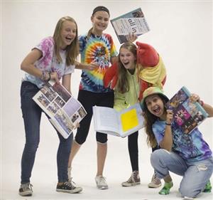 Girls holding yearbooks, laughing 