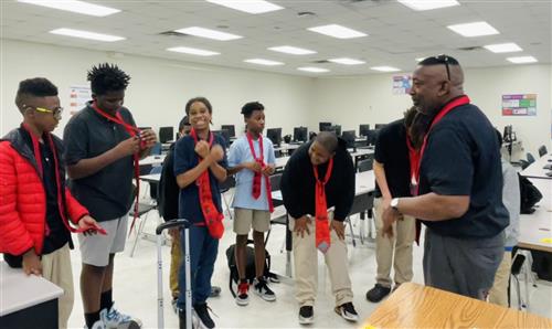 Mr. Thurman teaching the boys to tie ties