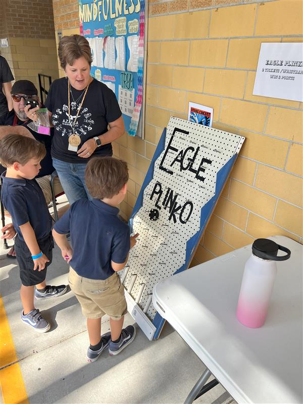 Students using some luck to win at Plinko!