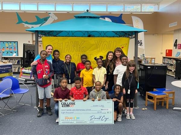 Sandy Lane Elementary Principal Kelly Austin was honored to receive a check from two representatives of the 2022 Sugar Sand Festival.