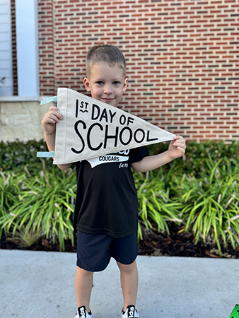 Student with a flag on the first day of school.