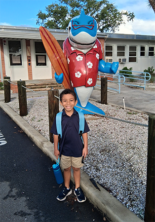 Student and school shark mascot on the first day of school.
